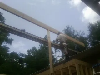 Carpenter setting a ridge beam over a new addition frame — Ice Dam Removal by Roofing Brothers in Wysox