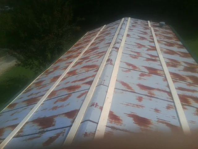 Rusted metal roof panels with new wood purlins before replacement — Storm Damage Roof Repair in Wysox by Roofing Brothers