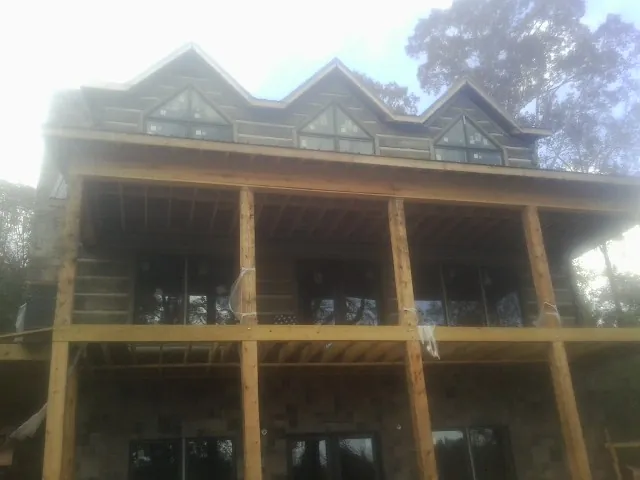 Dormers and porch framing on a large log home under construction — Roof Coating work by our crew in Wysox