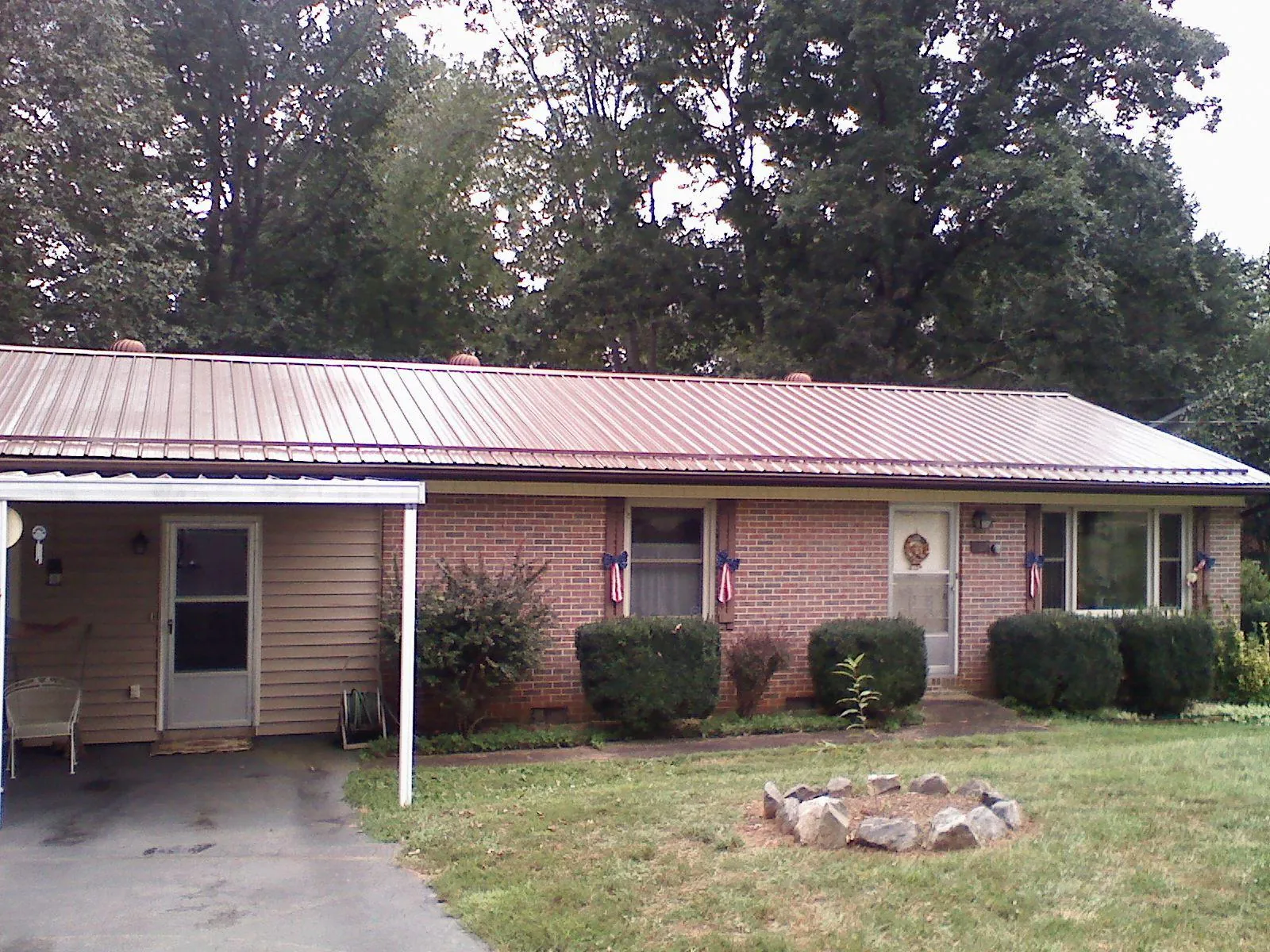 Bronze metal roof and carport on a brick ranch home — Roof Repair work by our crew in Wysox